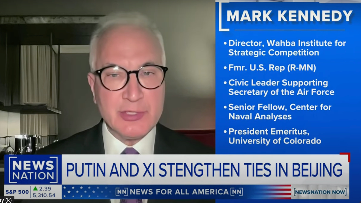 A man wearing glasses and a suit speaks during a news broadcast. Next to him, a blue panel lists his credentials, and a headline below reads, Putin and Xi strengthen ties in Beijing. News Nation branding is visible.
