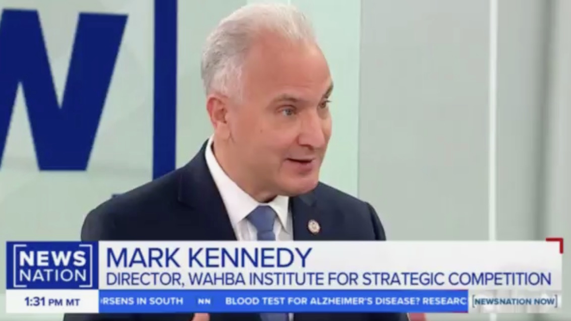 A man in a suit and tie speaks during a televised news segment. On-screen text identifies him as Mark Kennedy, Director of the Wahba Institute for Strategic Competition. The NewsNation logo and headlines are visible at the bottom.
