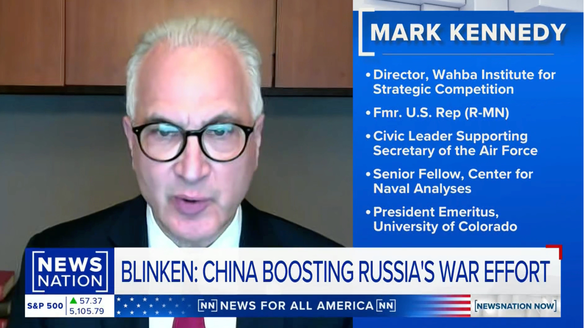 A man with glasses and gray hair appears on a news broadcast. Text on screen identifies him as Mark Kennedy and lists his credentials. The news headline below reads: Blinken: China Boosting Russias War Effort.
